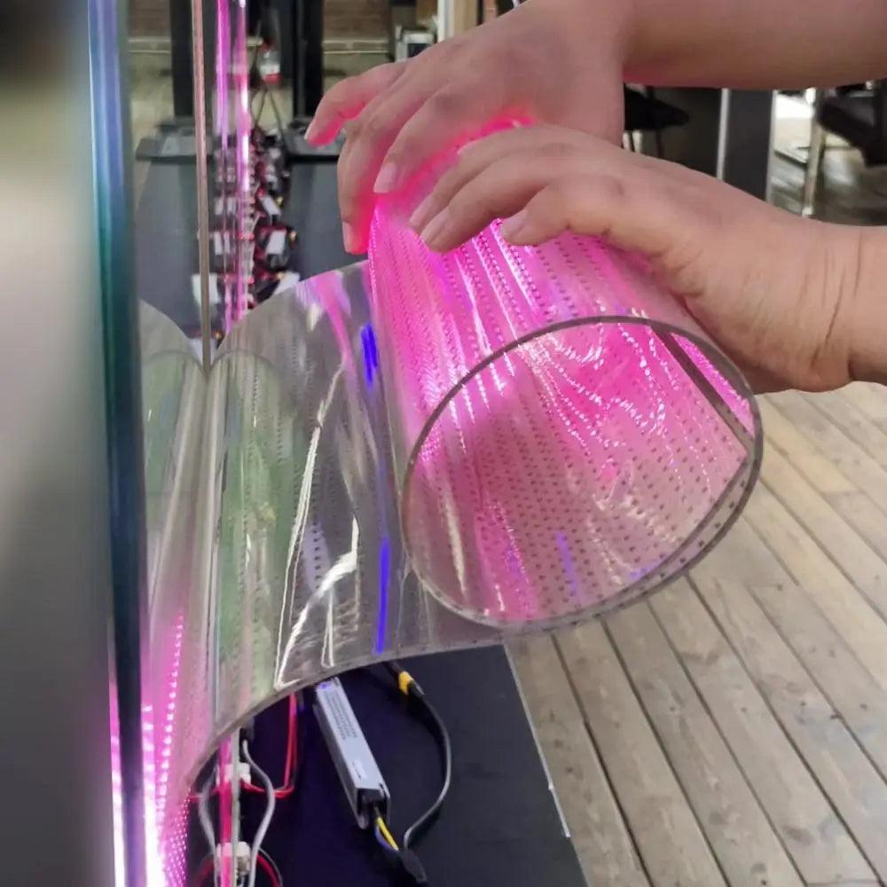 Film LED transparent souple manipulé à la main, éclairé en rose et bleu